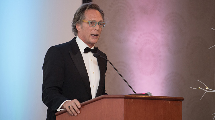 Actor Bill Fichtner speaks at a podium at the Brockport Alumni Gala