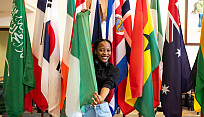 Student holding flags that represent countries all over the world