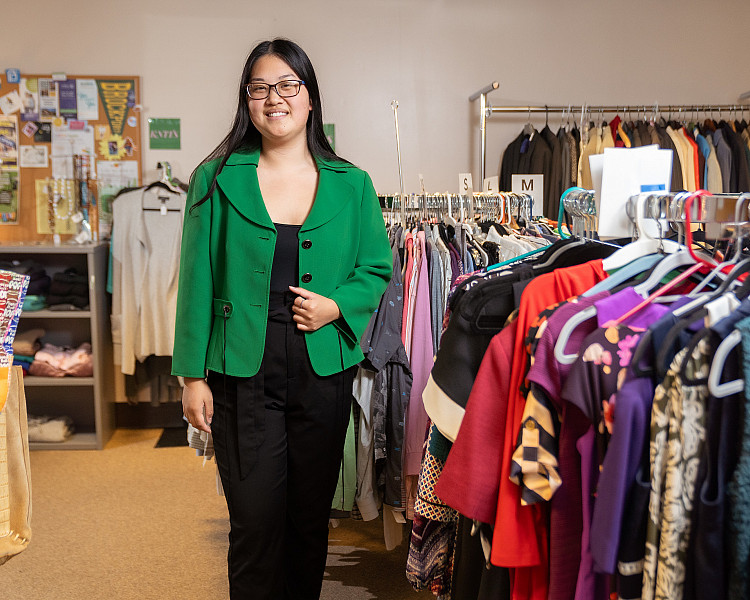 Student standing in professional attire in the Professional Clothes Closet on campus