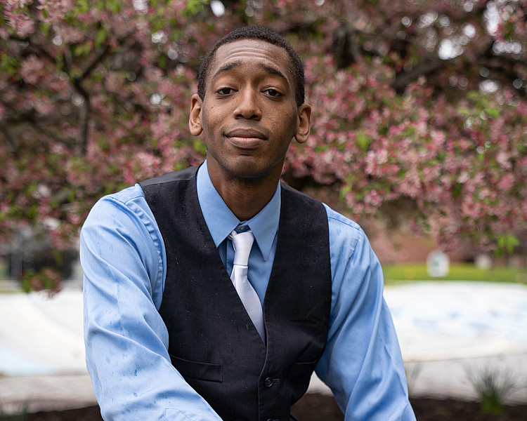 Student sitting by graffiti wall