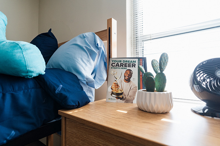 Close up of a magazine titled, Your Dream Career Starts Here, on top of a dresser next to a bed