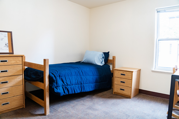 Entrance view of a bedroom with a dresser, bed, and nightstand