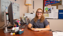 Madi Hiddie sitting at her desk in the Center for Career Design & Experiential Learning.