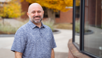Tony Tepedino standing outside of Jitterbugs Cafe on campus at SUNY Brockport