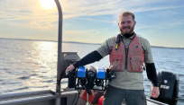 Kyle Morton, a SUNY Brockport Master of Science in Environmental Science and Ecology graduate, on a boat.