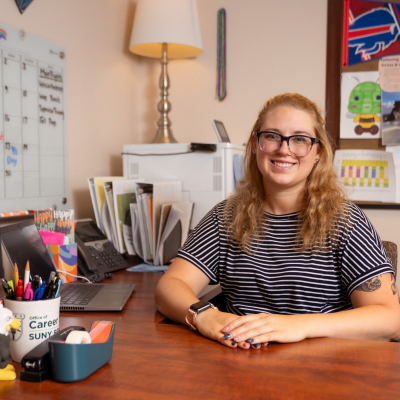 Madi Hiddie sitting at her desk in the Center for Career Design & Experiential Learning.