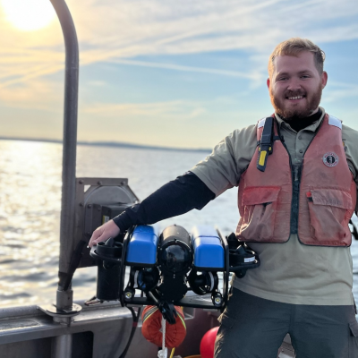Kyle Morton, a SUNY Brockport Master of Science in Environmental Science and Ecology graduate, on a boat.