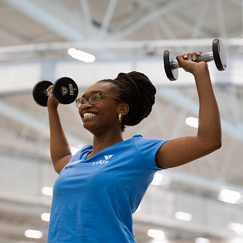 Anaheysha Baptiste-White working out with dumbells.
