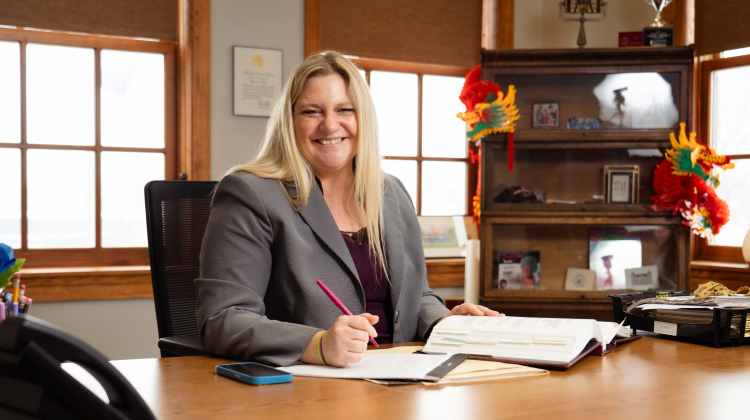 Rachael Tabelski sitting at a desk with a pen in her hand.