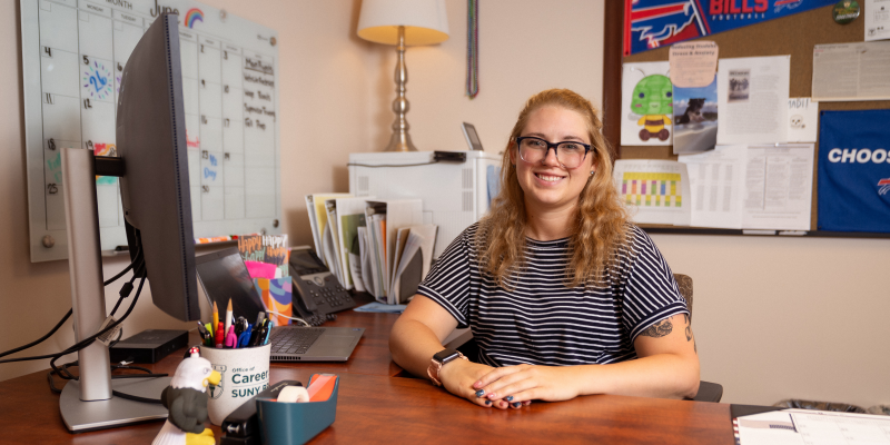 Madi Hiddie sitting at her desk in the Center for Career Design & Experiential Learning.