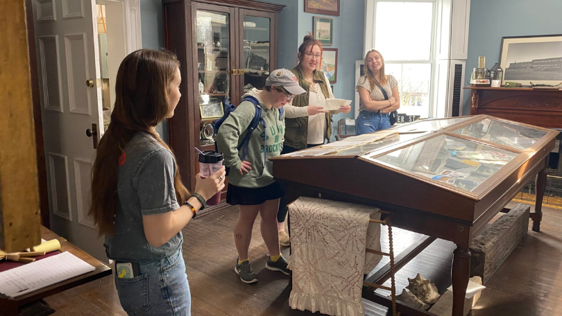 Four people standing in the Brockport Museum of Local History and discussing Fannie Barrier Williams' legacy.
