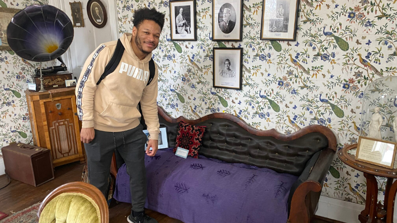 Fannie Barrier Williams Project participant, Roshaun Brown-Hall, pictured with Williams' couch from her Brockport, NY house.