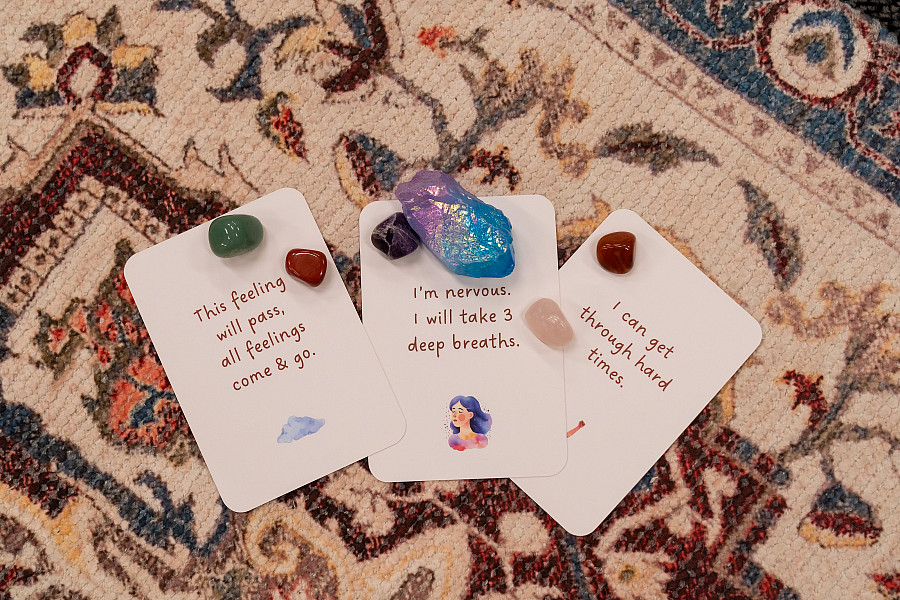 Words of affirmation cards on a meditation rug surrounded by crystals.