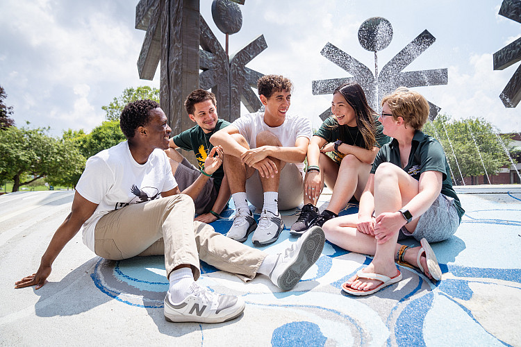 Orientation Leaders sitting in front of the fountain in summer