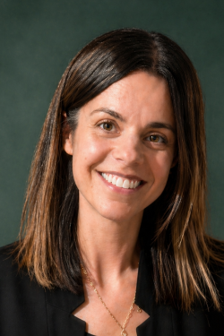 Female with long brown hair and brown eyes. She is smiling.